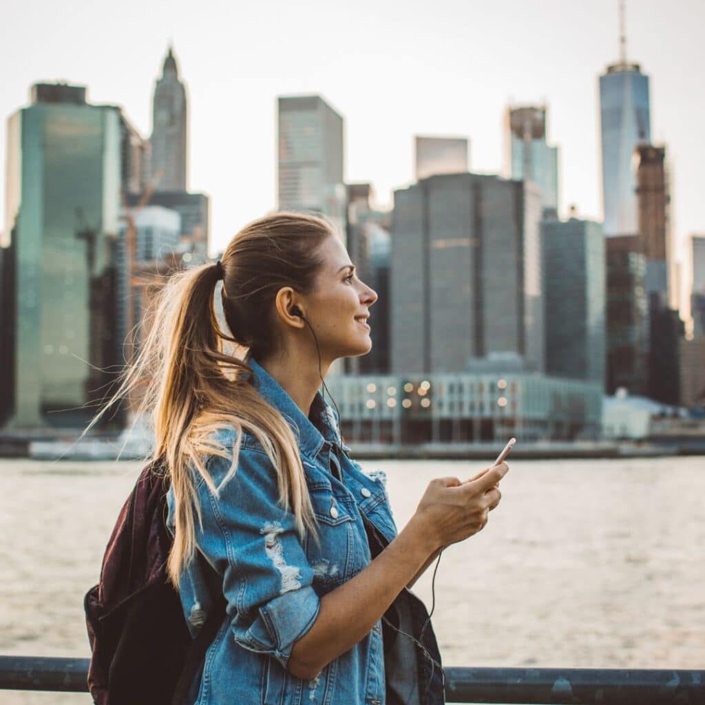 eine Frau mit einem Telefon vor einer Stadt Der Entdecker Archetypen im Branding