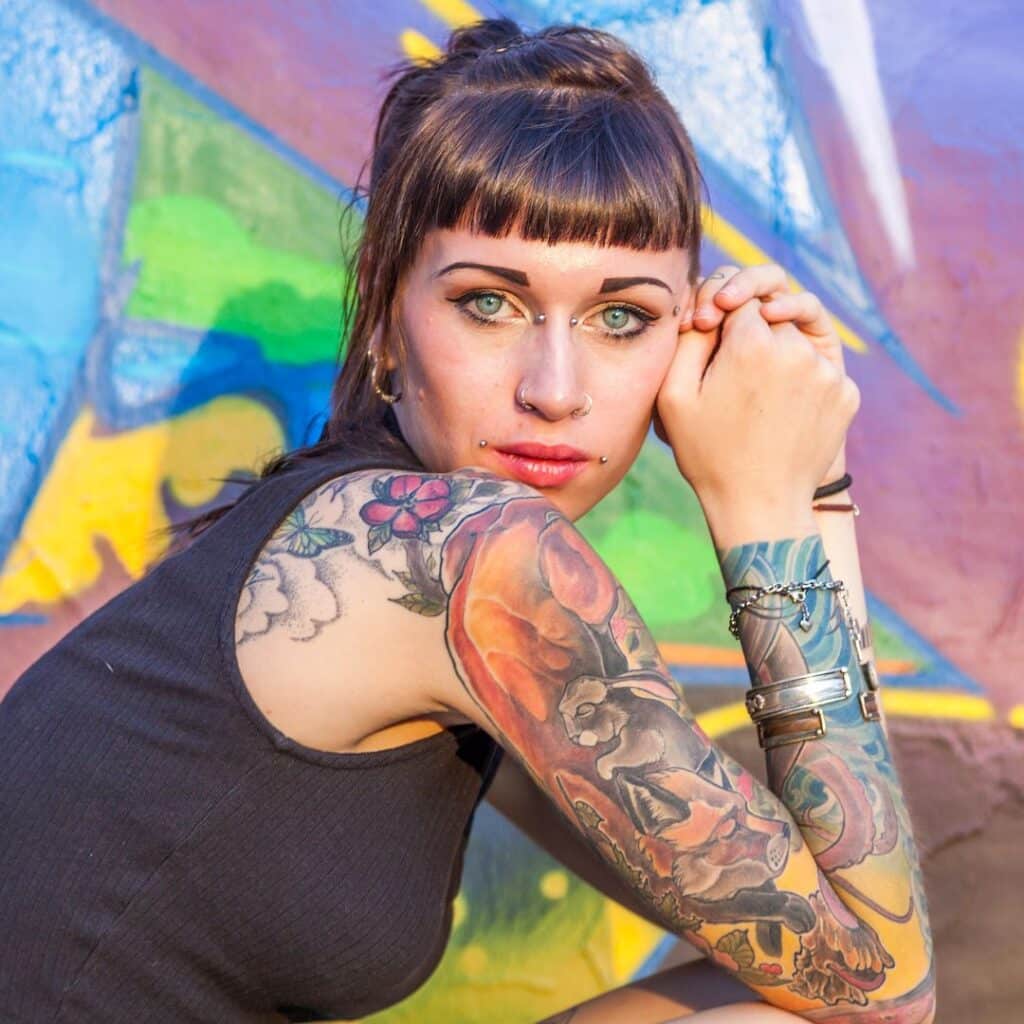 eine Frau mit Tattoos posiert für ein Foto der Rebell