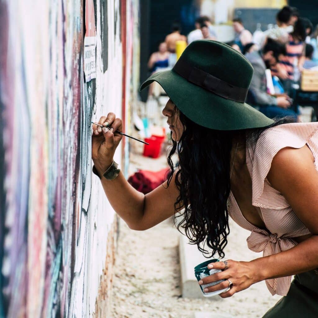 eine Frau malt an einer Wand der Schöpfer-archetypen im Branding