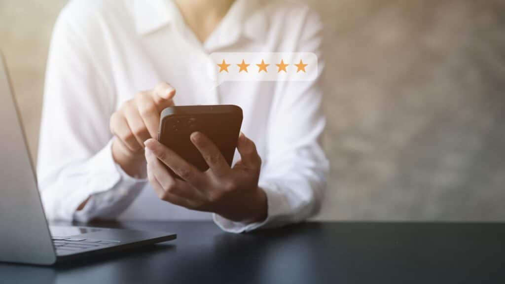 a person holding a phone with stars-Social Proof Kundenbewertungen Preisstrategie Beispiele
